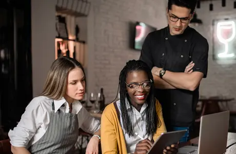 Image of a group of smiling kitchen workers standing side by side.